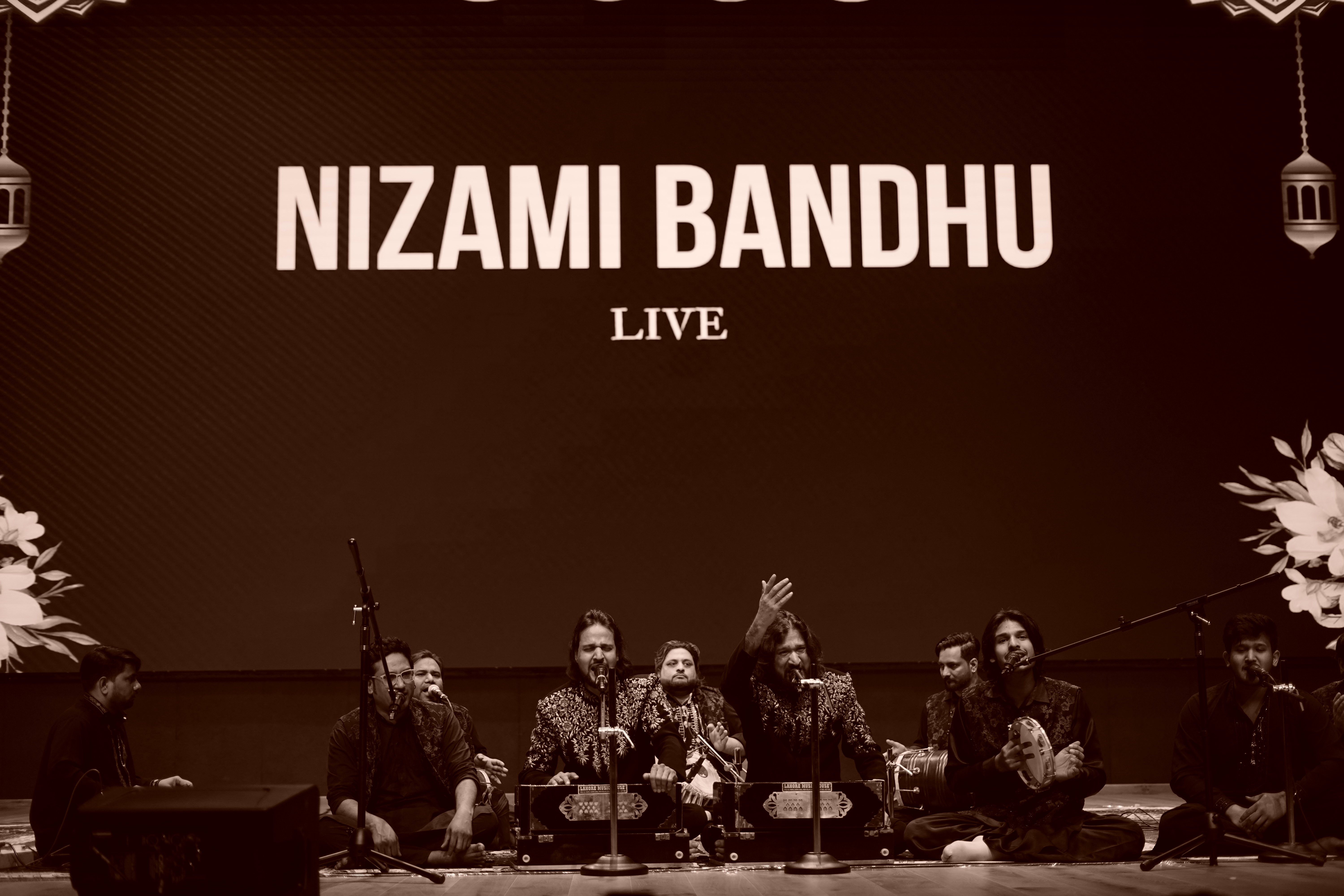 Nizami Bandhu on stage — black and white
